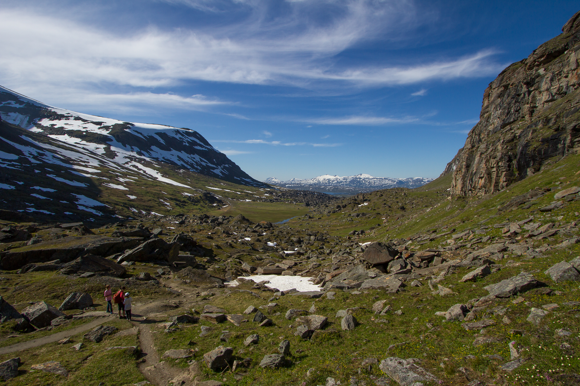 Hikers walking through the boulders in the valley go Kärkevagge, Swedish Lapland.