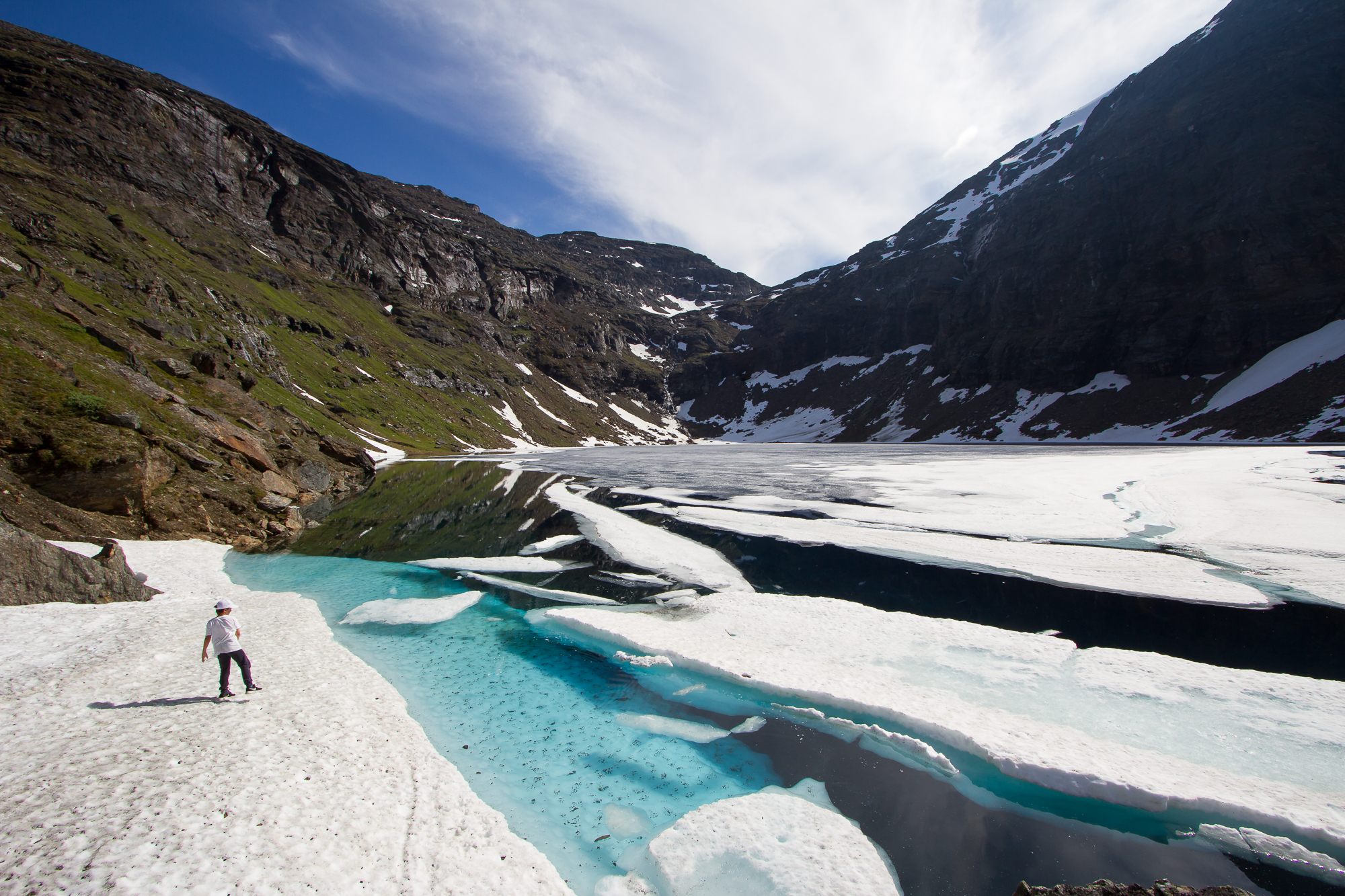 Boy on the shore of lake Trollsjön, still partly covered with ice in July.
