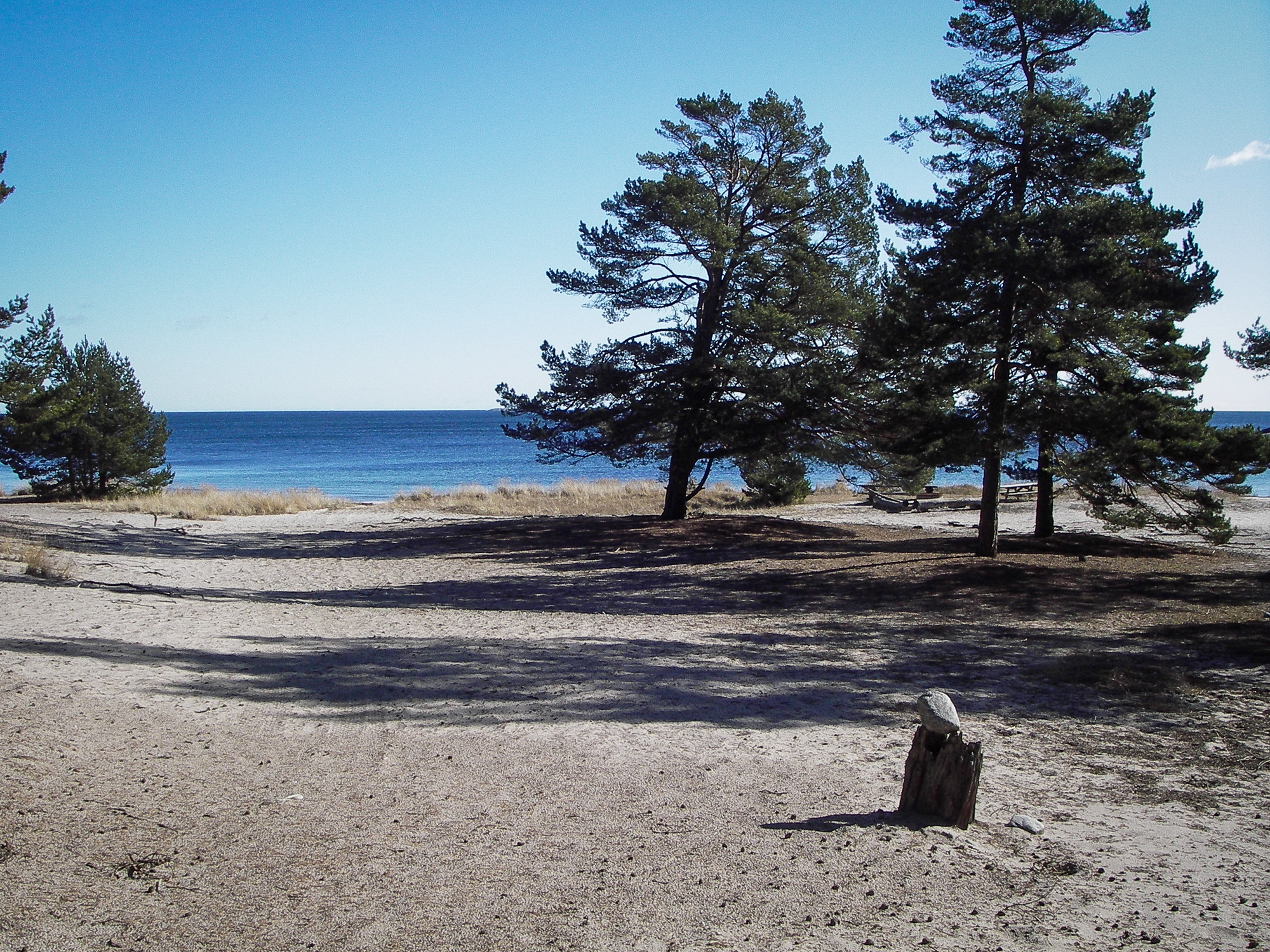 Vy över sandstrand ut mot havets horisont.