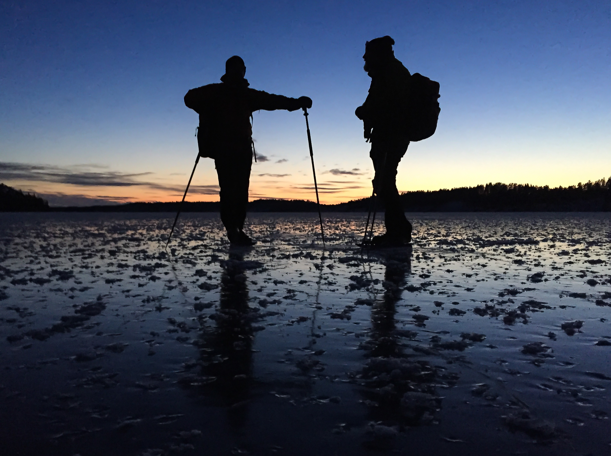 Silhuetter av långfärdsskridskoåkare på Nynäsviken, Nynäshamn.