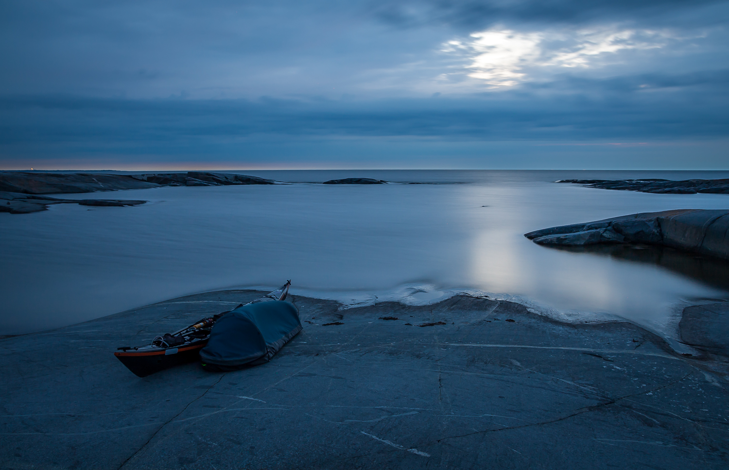 Havskajakpaddlare i natthamn i bivacksäck på Håkanskär, Stockholms norra skärgård