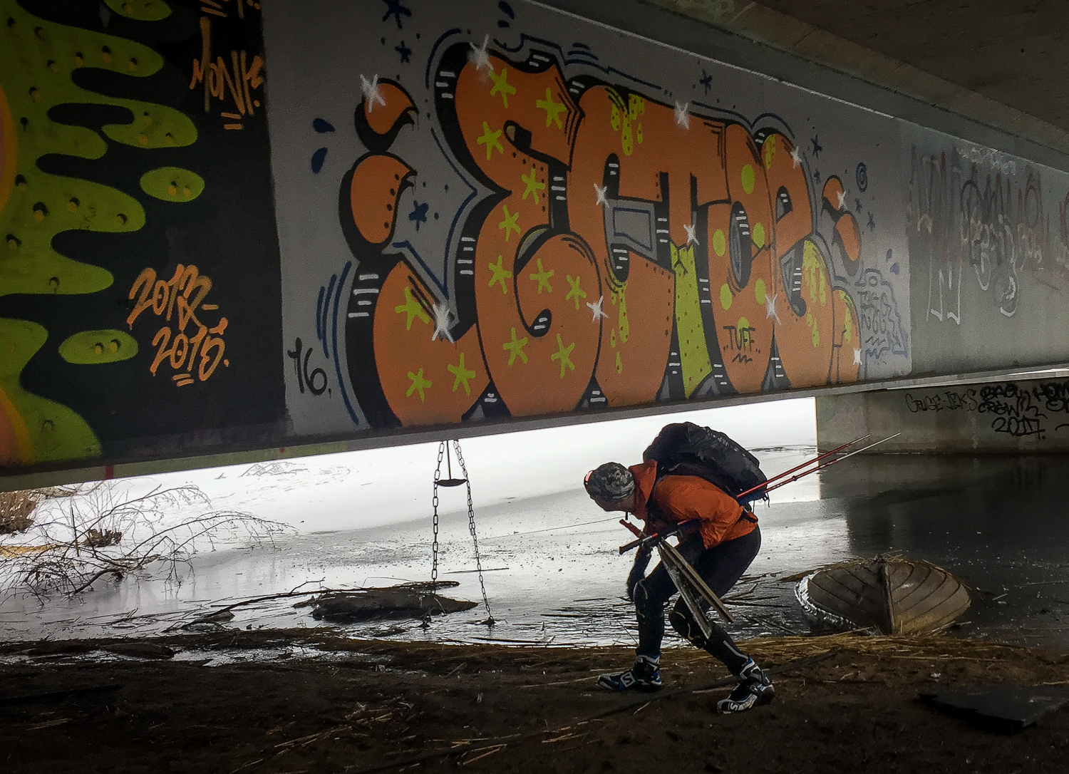 Långfärdsskridskoåkare går under en graffitimålad vägbro