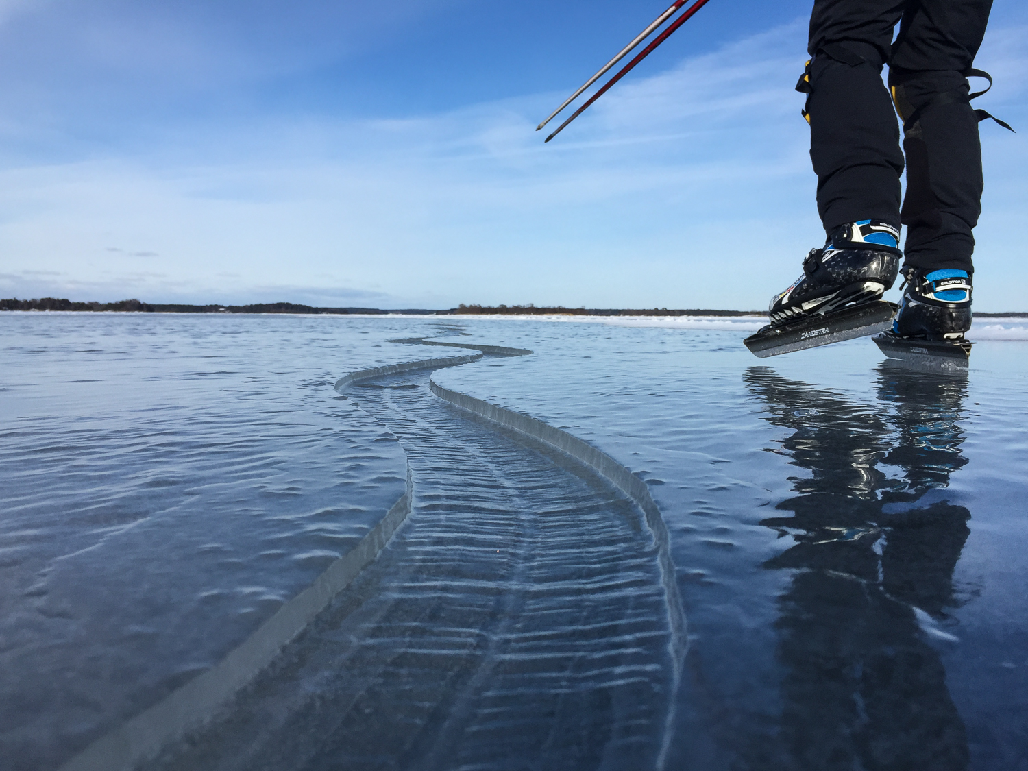 Långfärdsskridskoåkare åker längs en slingrande spricka i Stockholms skärgård