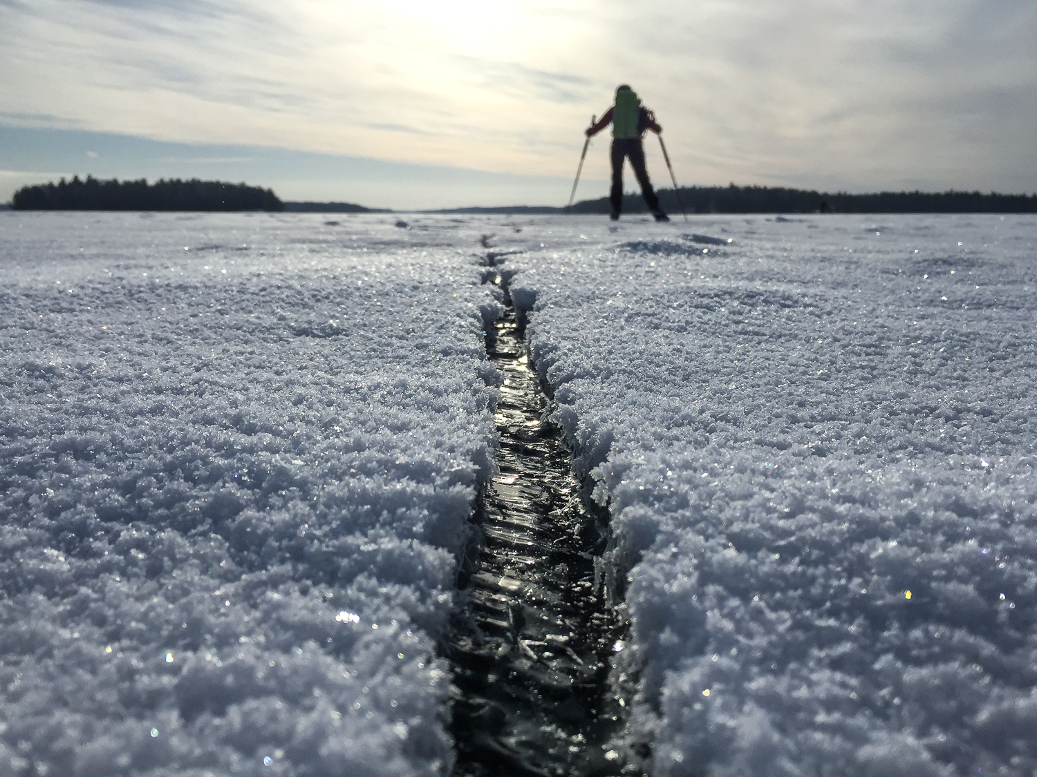 Långfärdsskridskoåkare passerar en spricka i isen på Björkfjärden