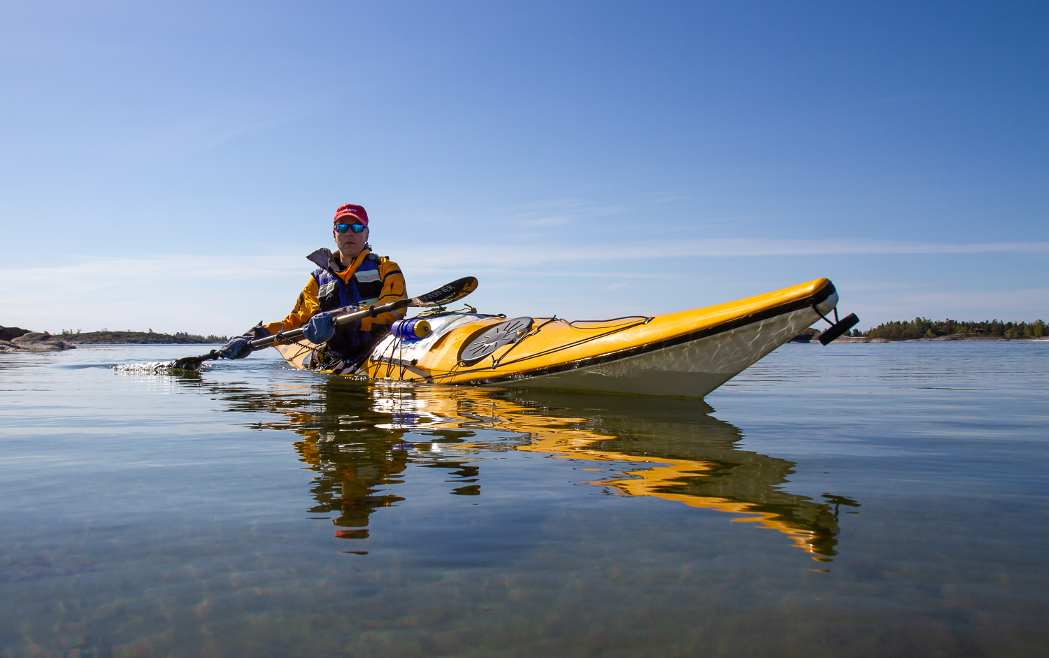 Kajakpaddlare skär genom blankt vatten