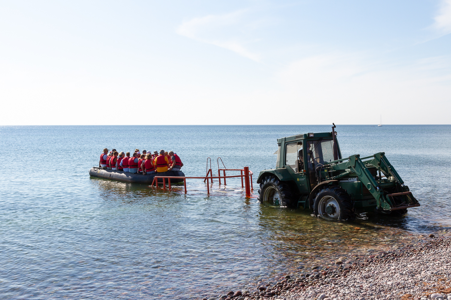 En gummibåt med passagerare blir sjösatt med hjälp av traktor, Gotska Sandön