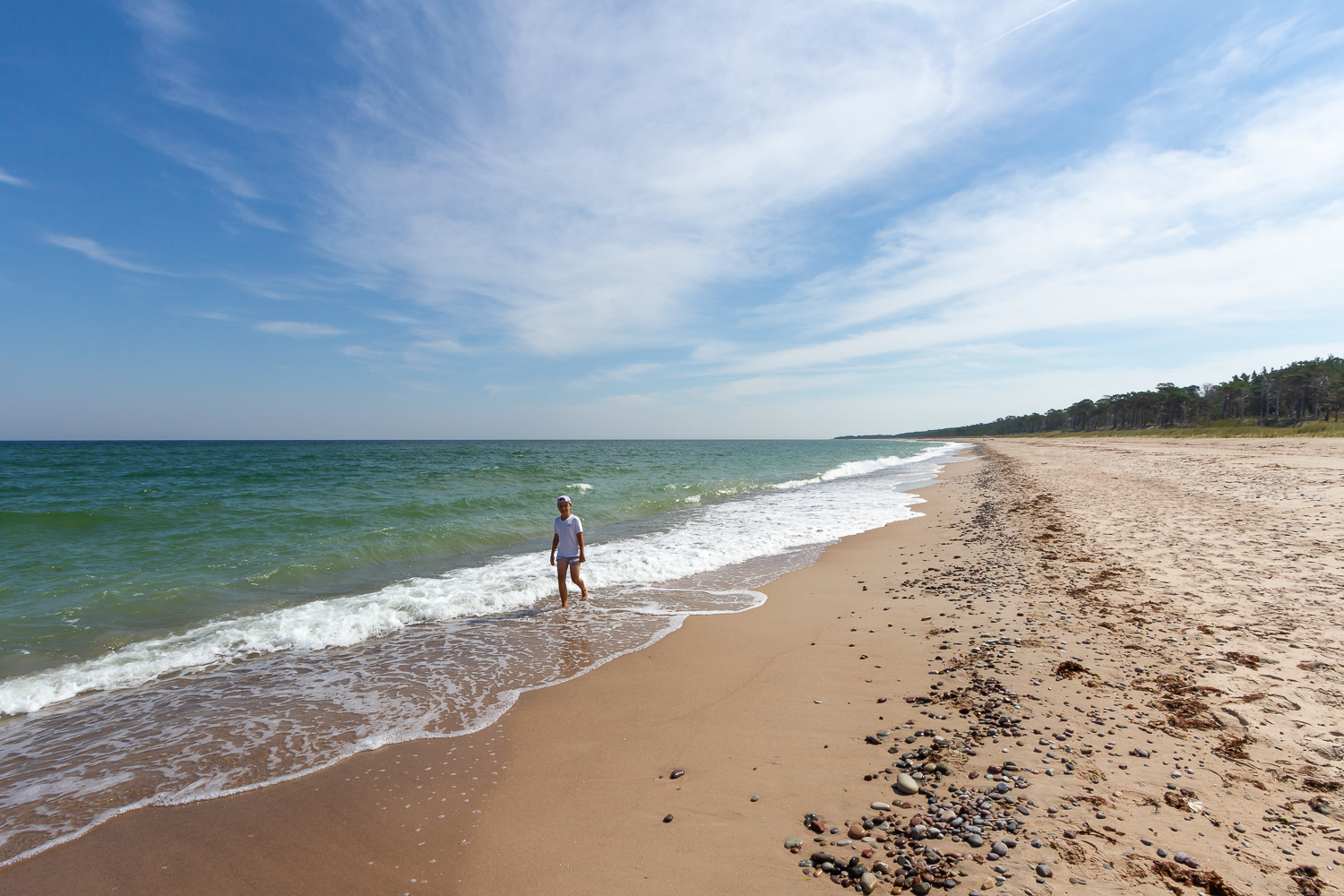 En kille promenerar längs en sandstranden Las Palmas på Gotska Sandön