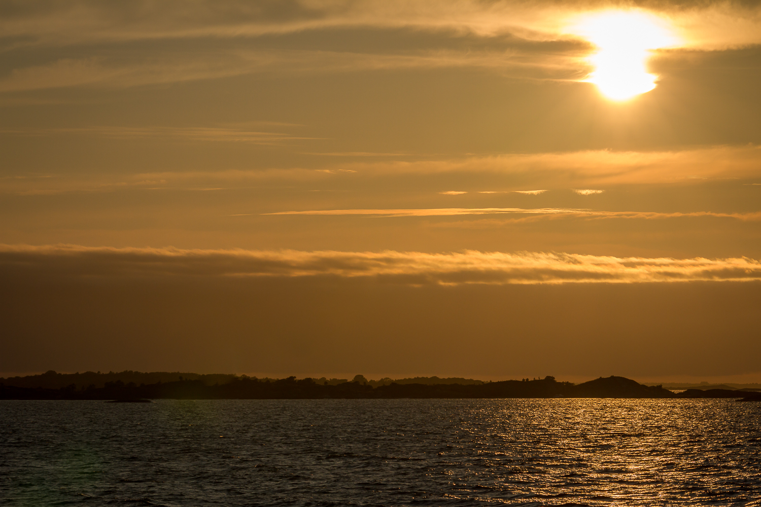 Silhouetter av kobbar och skär i solnedgång över Ängskärs skärgård, Stockholms skärgård