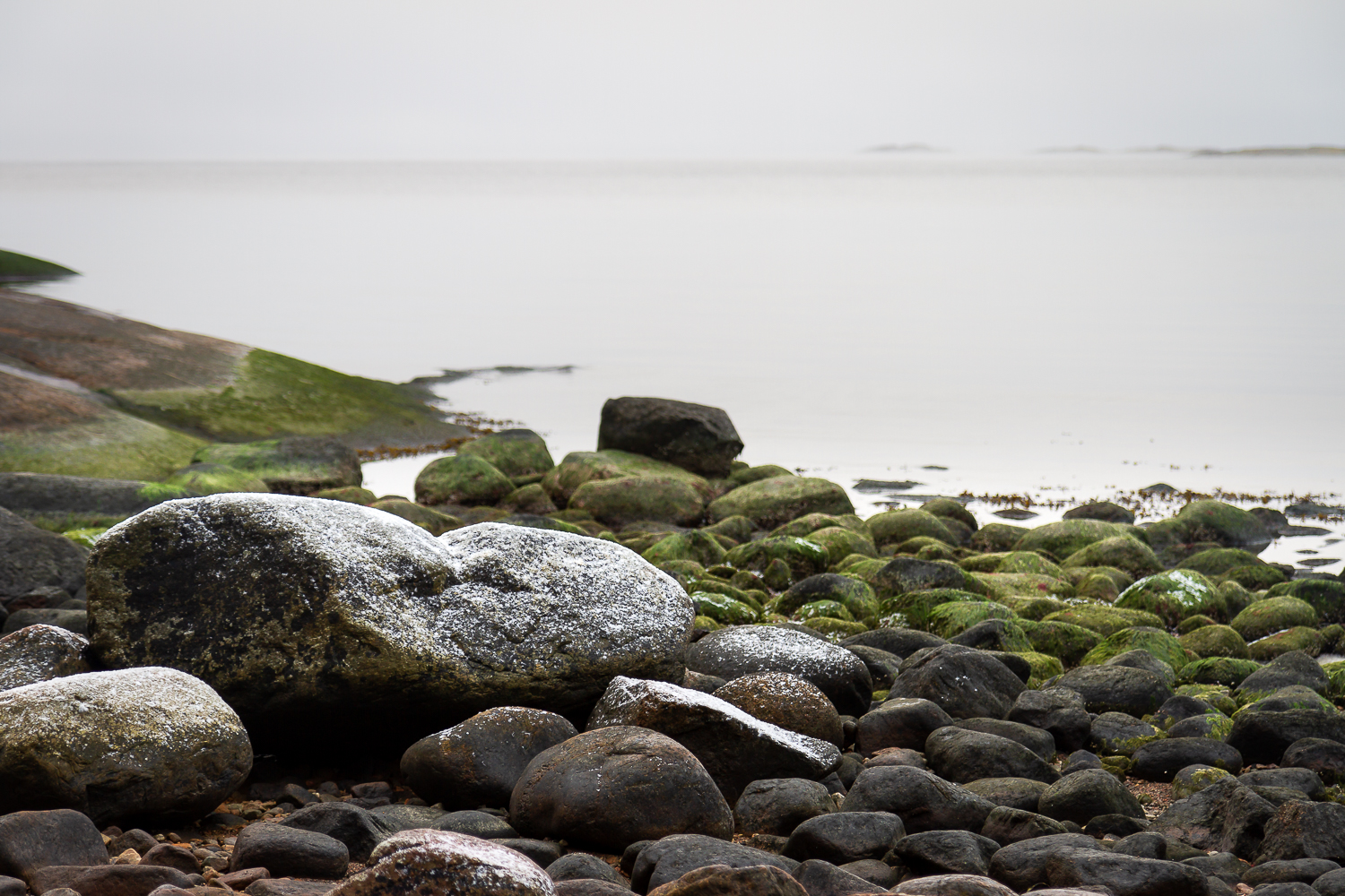 Pudersnö över stenar på stranden, Sörmlands skärgård