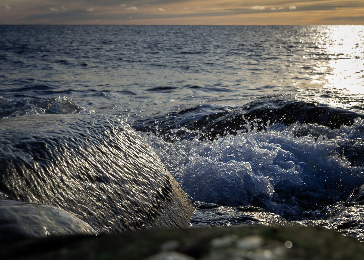 Vågor sköljer över stenar på stranden på Tärnskär och bildar en klar isskorpa