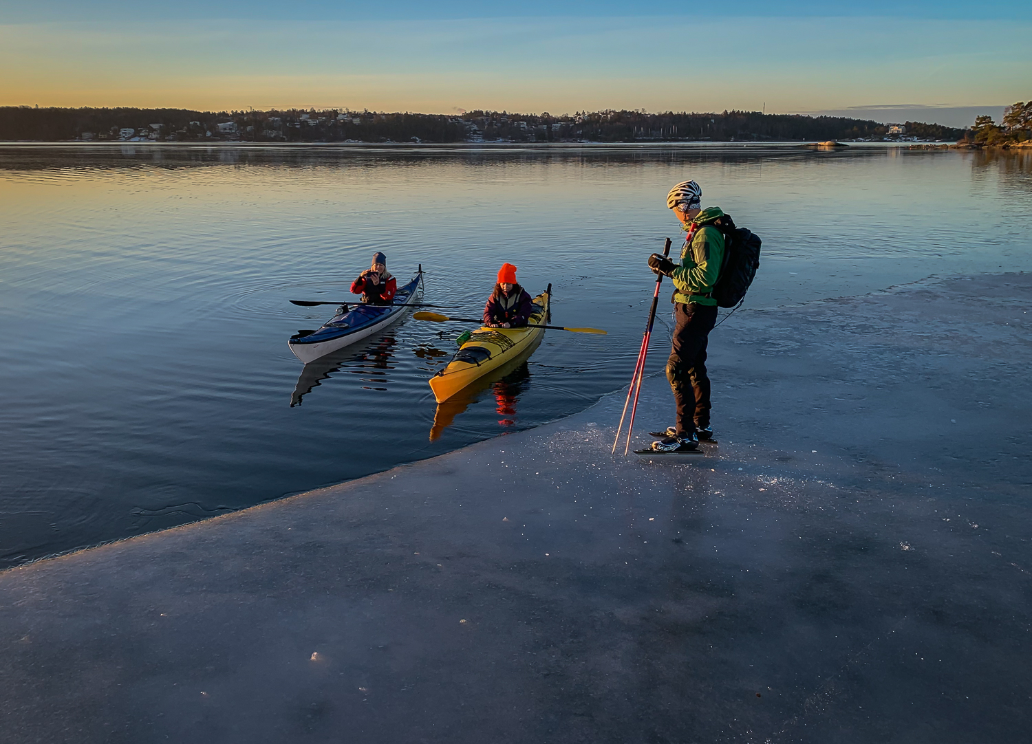 Långfärdsskridskoåkare möter kajakpaddlare i gryningen längs iskanten på Stora Värtan