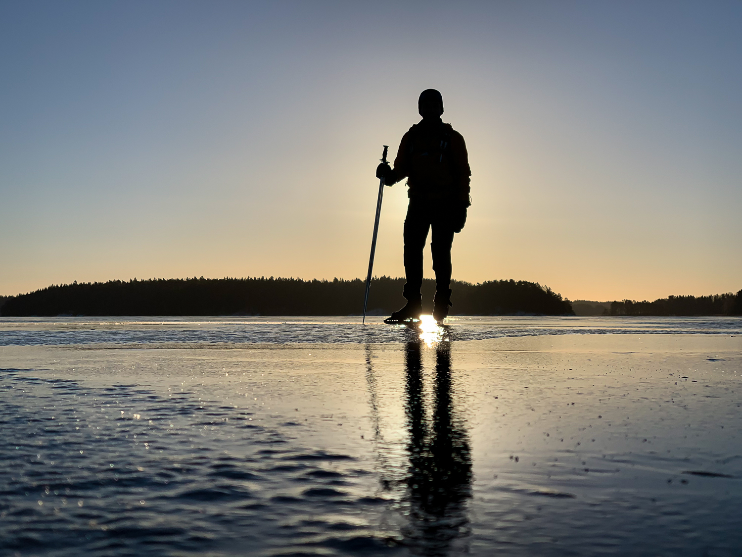 Långfärdsskridskor i soluppgången på sjön Båven, Sörmland