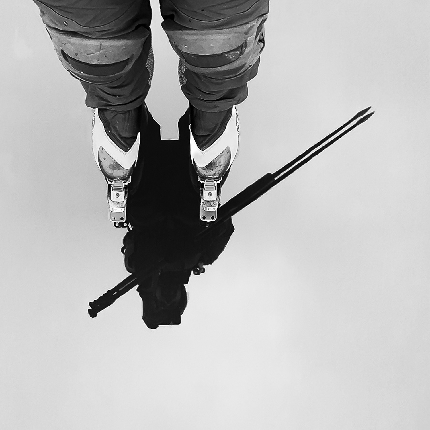 Långfärdsskridskoåkare speglar sig i blank kärnis