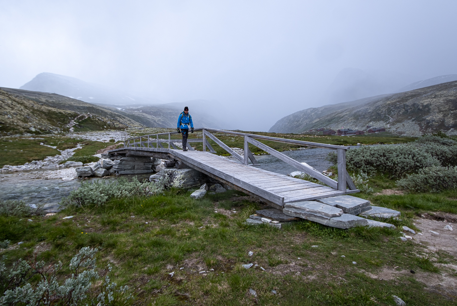 En person vandrar över en bro i Rondane nationalpark, Norge